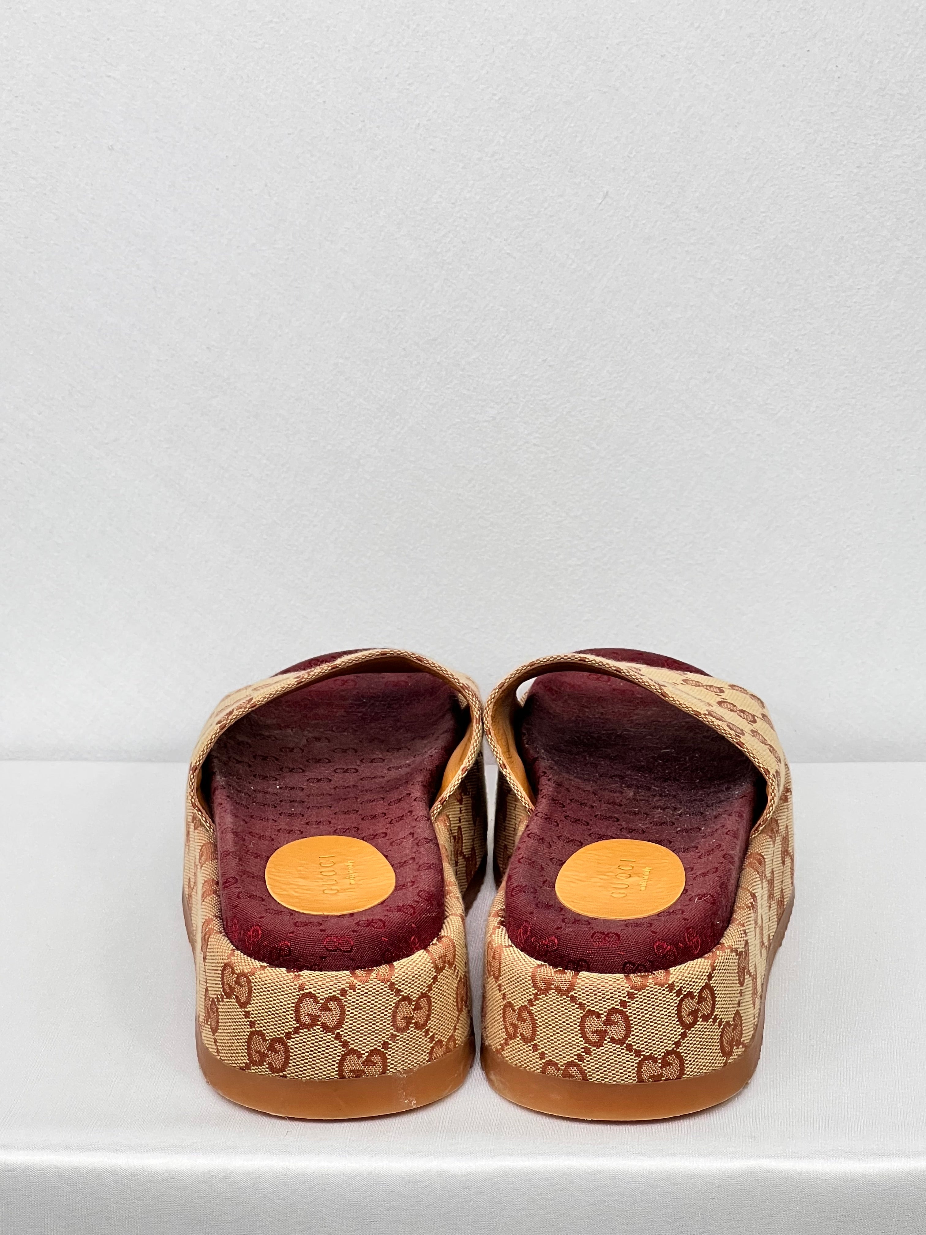 Rear view showing heel shape and canvas detailing on Gucci GG platform sliders.