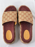 Top view of Gucci GG platform sliders showing wide canvas strap and burgundy cushioned footbed.