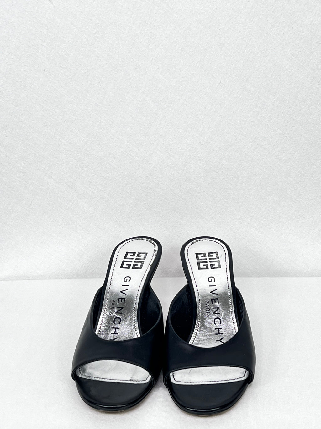Pre-owned Givenchy leather mules showing open-toe design and branded insole, front view.
