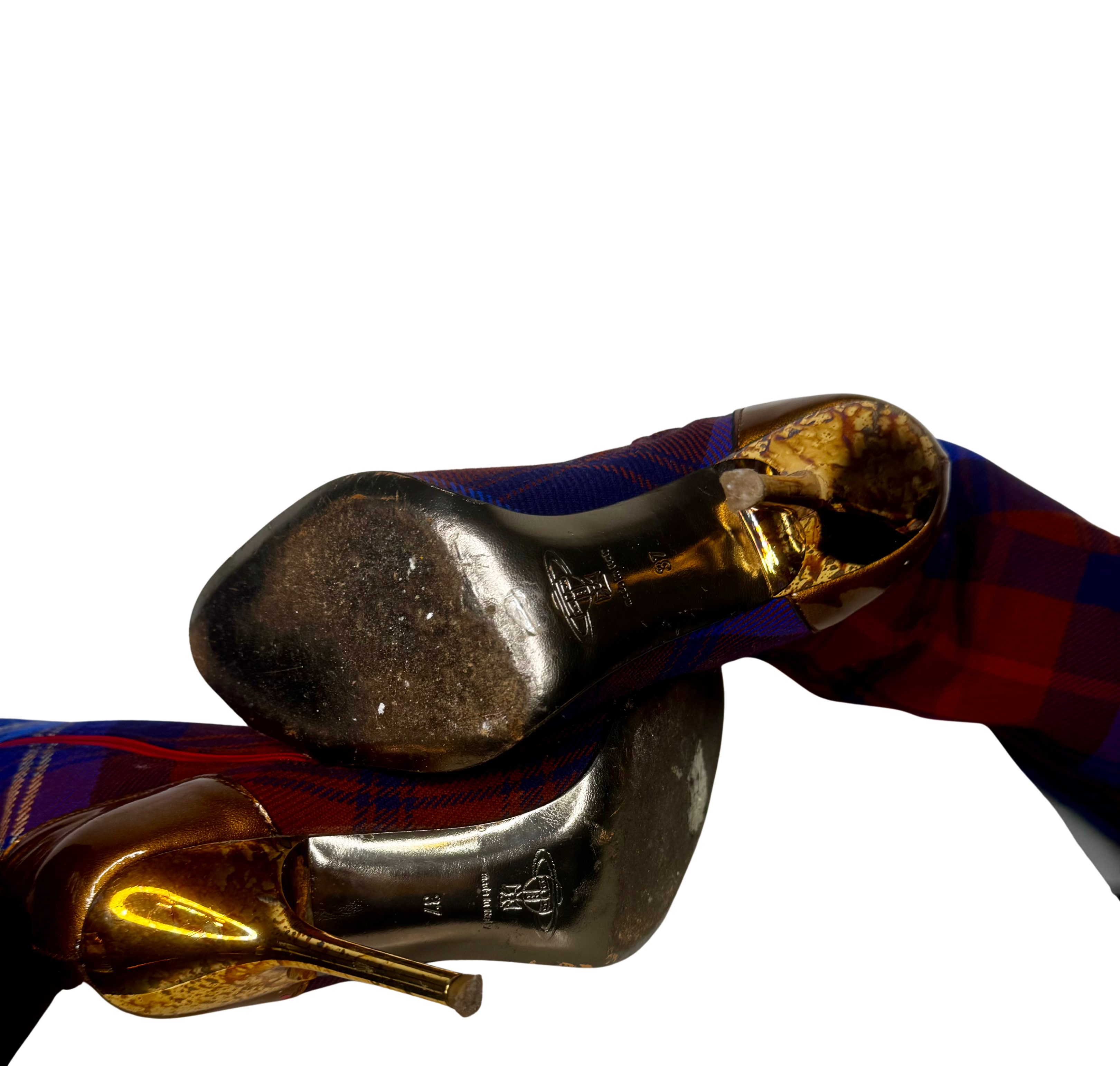 Close-up of soles on Vivienne Westwood tartan over-the-knee boots showing embossed branding and signs of gentle pre-owned wear.