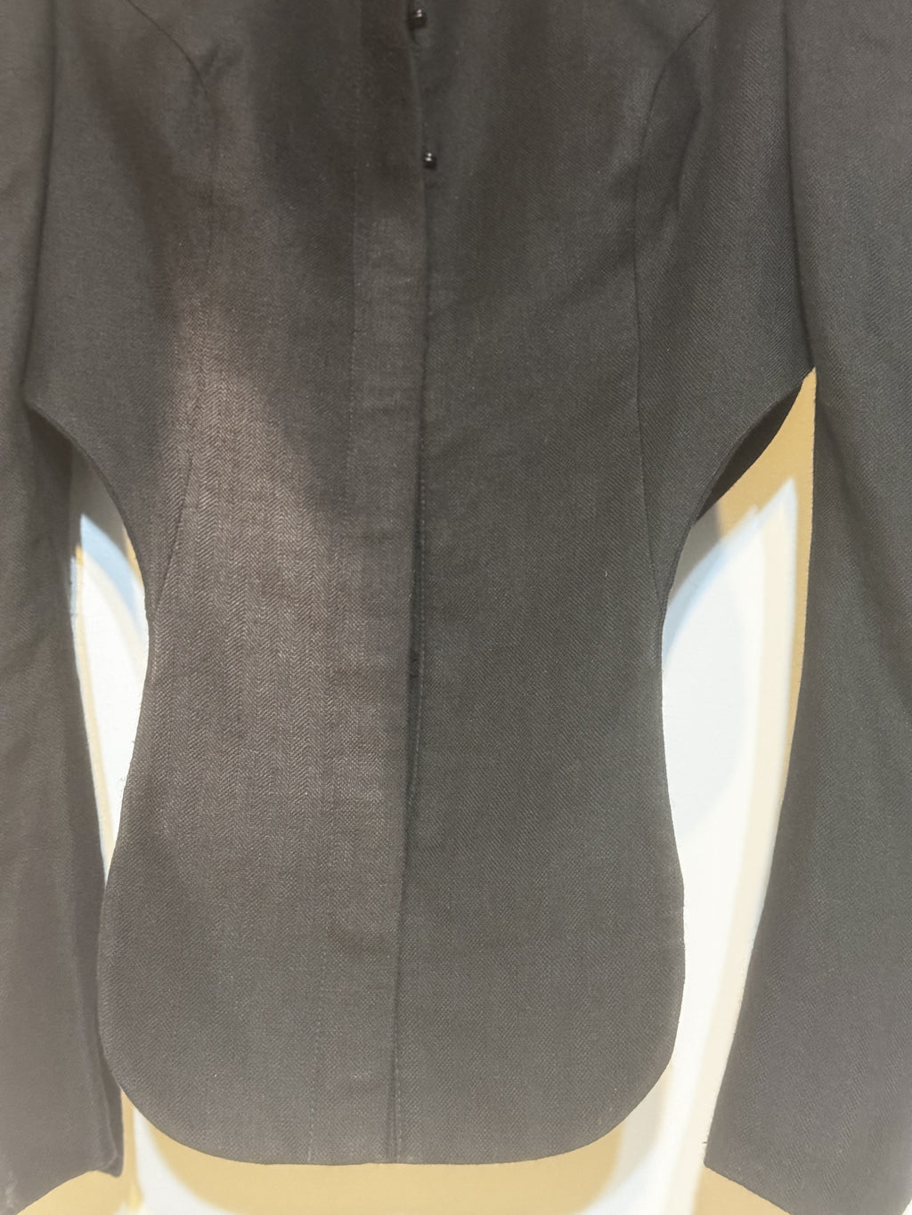 Close-up of the  vintage Vivienne Westwood cropped jacket showing precise seam lines and sculpted silhouette.
