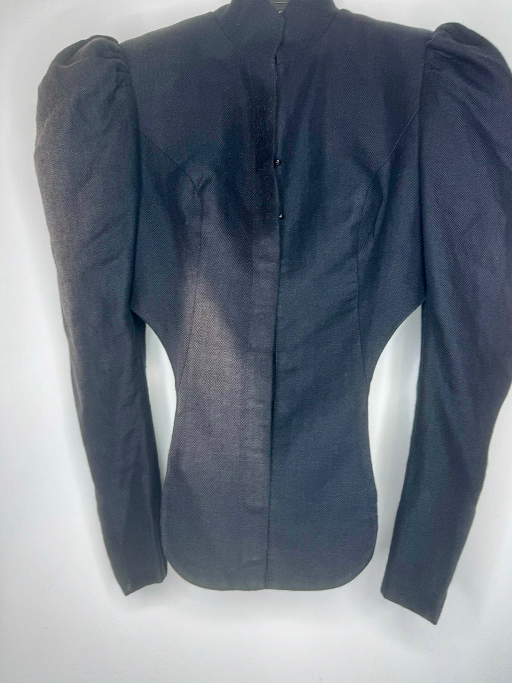 Front detail of vintage Vivienne Westwood cropped black jacket showing fitted waist, structured tailoring and button fastening.