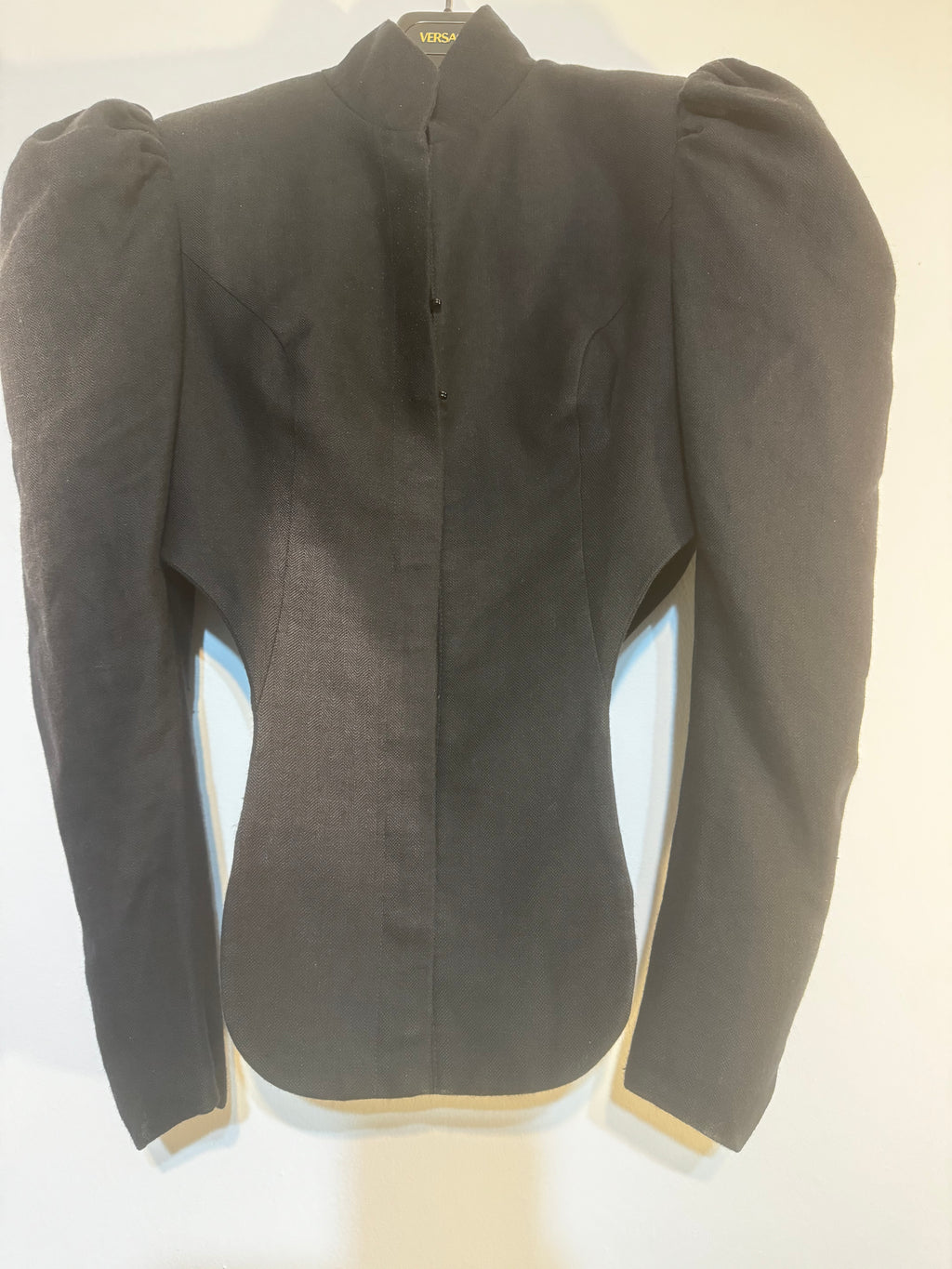 Front detail of vintage Vivienne Westwood cropped black jacket showing fitted waist, structured tailoring and button fastening.